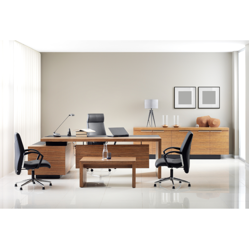 Modern office with wooden desks, black swivel chairs, a table lamp, decorative items, and framed wall art. Large windows on the left allow natural light to fill the bright, minimalist space.
